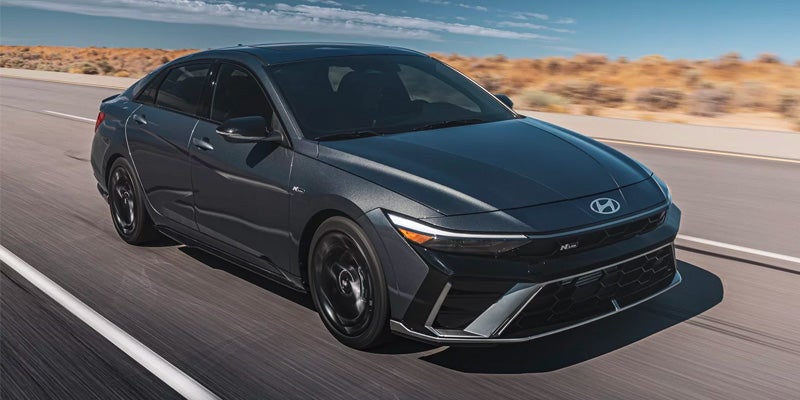 Dark gray Hyundai sedan, front-left three-quarter view, driving