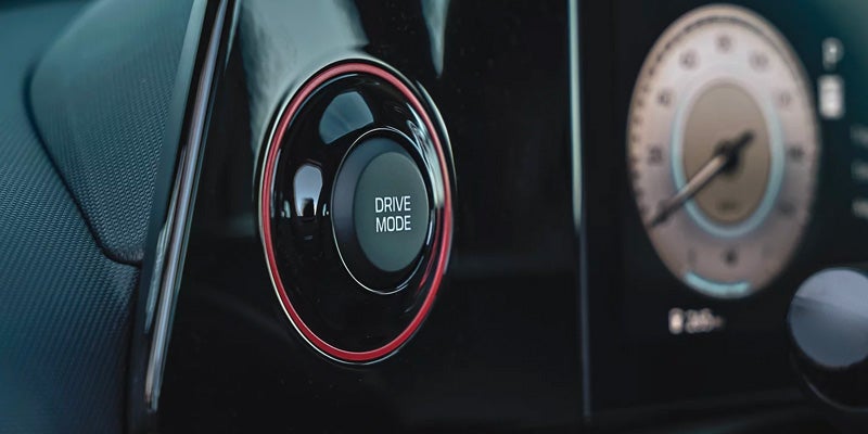Close-up of a circular drive mode selector with red illumination.