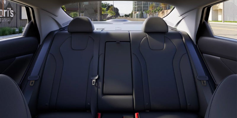 View of the empty black leather rear passenger seats inside a car.