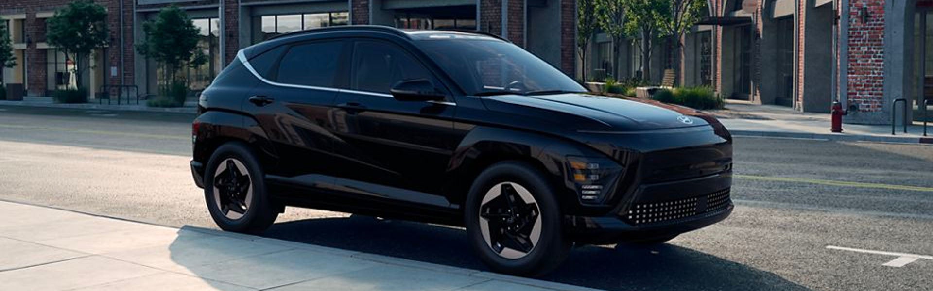 A sleek black Hyundai Kona Electric parked on a sunny city street.