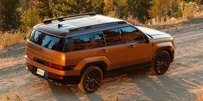 High-angle rear view of a bronze Hyundai Santa Fe on dirt