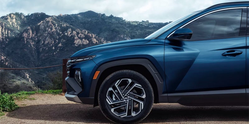 Detailed view of the front wheel and fender of a blue SUV.
