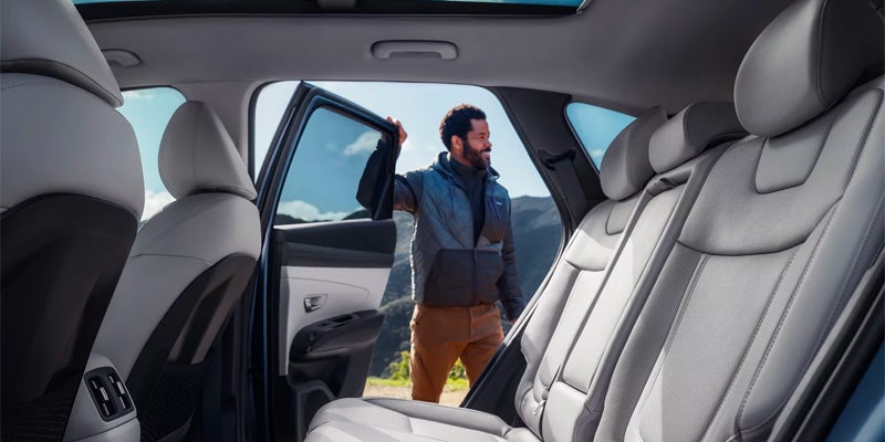 Spacious rear passenger seating inside a modern SUV with light upholstery.