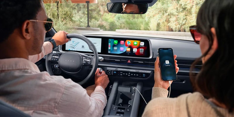 View from the backseat of people using the front dashboard screens