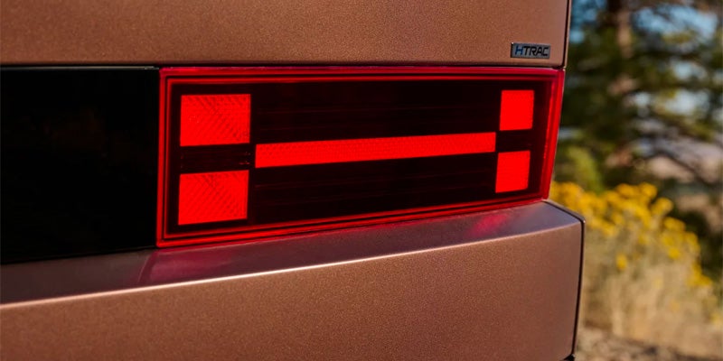 Detailed close-up of a red geometric LED taillight assembly.
