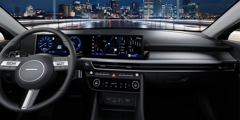 Modern car dashboard featuring a wide digital display and steering wheel.