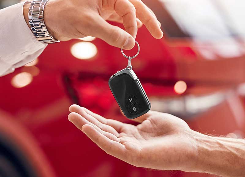 Handing over a car key fob to a new owner.